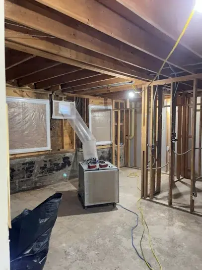 Dehumidifier running in a room opened to the studs for structural drying