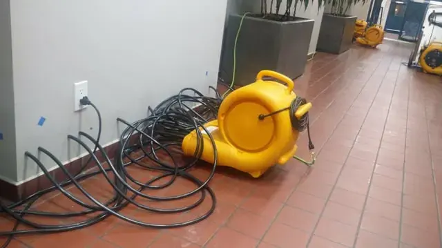 Air mover set on a tile floor to dry a wet room