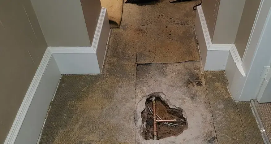 Floor opened to expose a leaking pipe under a Cedar Park slab